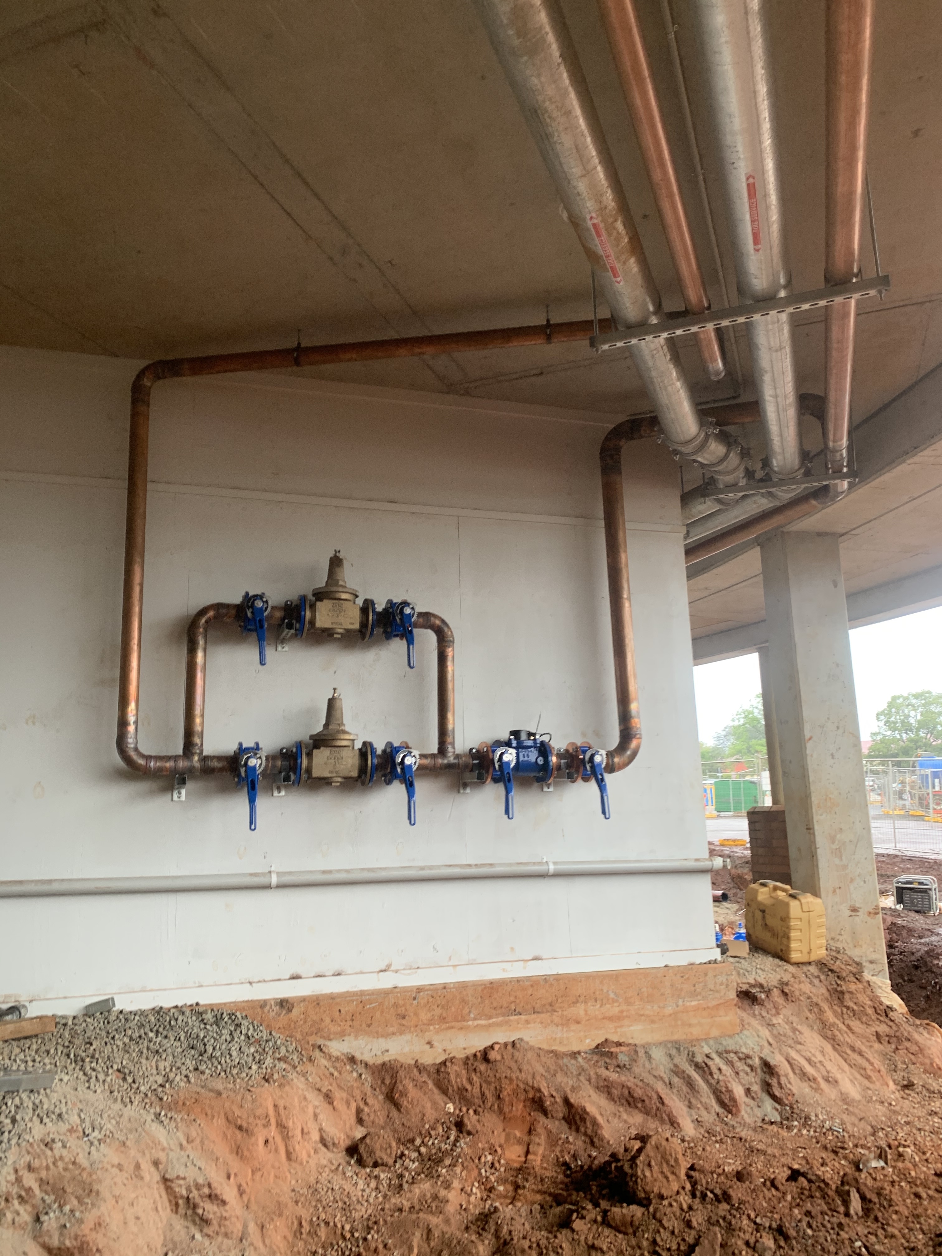 Copper backflow prevention valve manifold on commercial building